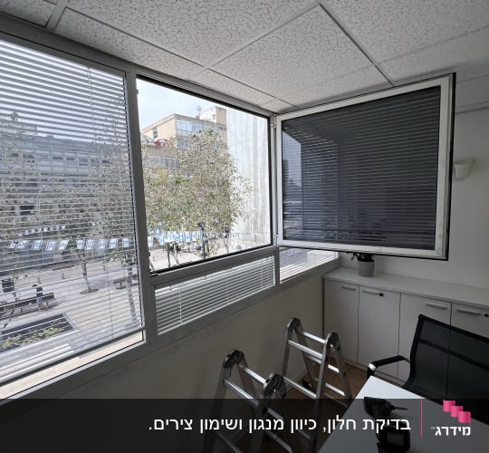 תריסים אופקיים על חלון משרדי עם סולם לידם